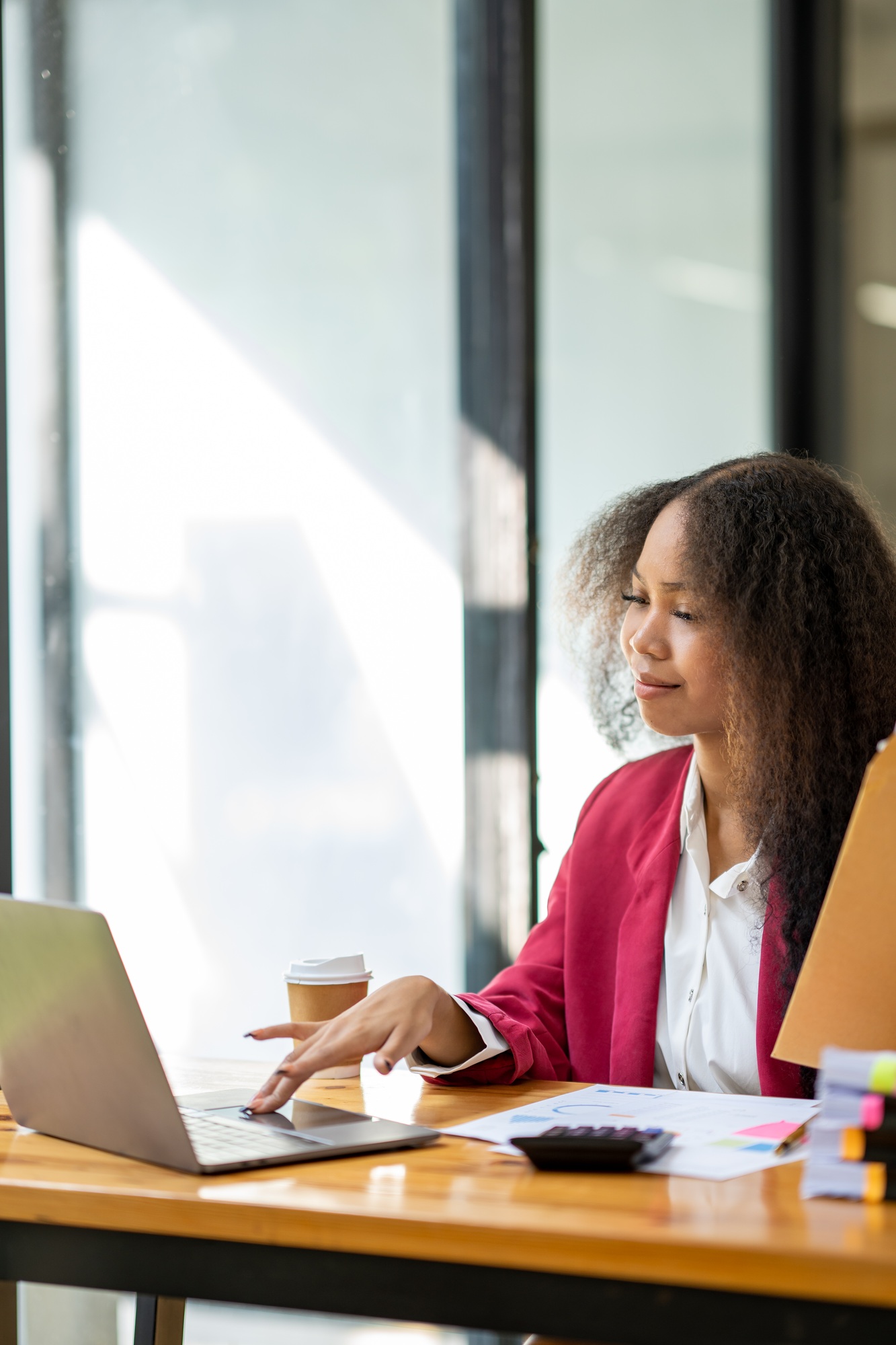 An African businesswoman holds a brown envelope on a table and opens a sheet of business information